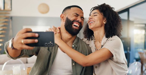 Kotiin, selfie ja pari rakkaudella, hauska ja hymyillä onnea ja sosiaalista mediaa olohuoneessa. Asunto, mies ja nainen oleskelutilassa, profiilikuva ja huumoria nauraen ja liimaten yhdessä. - Valokuva, kuva