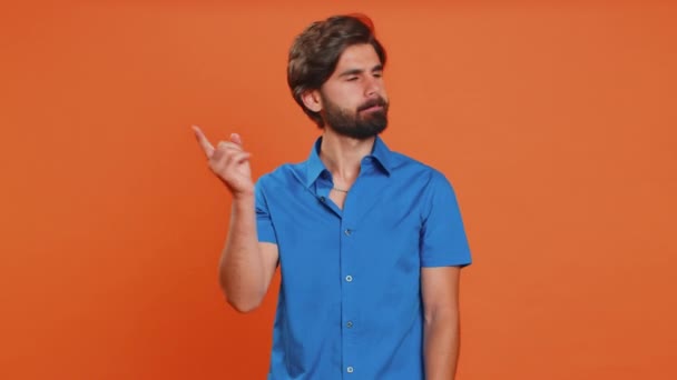 Displeased upset middle eastern man reacting to unpleasant awful idea, dissatisfied with bad quality, wave hand, shake head No dismiss idea dont like proposal. Guy isolated on orange studio background - Footage, Video