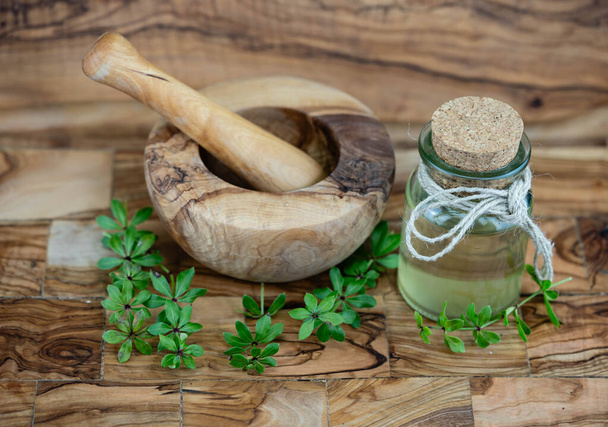 Vinagre Woodruff verde sobre madera de olivo - Foto, imagen
