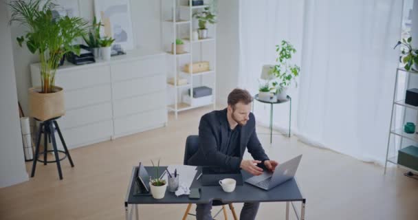 Furious nuori miesyrittäjä sulkeminen kannettava tietokone ja repiminen paperi kävellessään pois työpöydän yrityksen työtilassa - Materiaali, video