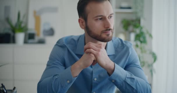 Jóképű fiatal férfi vállalkozó gondolkodás stratégia, miközben ül a vállalati munkaterület - Felvétel, videó
