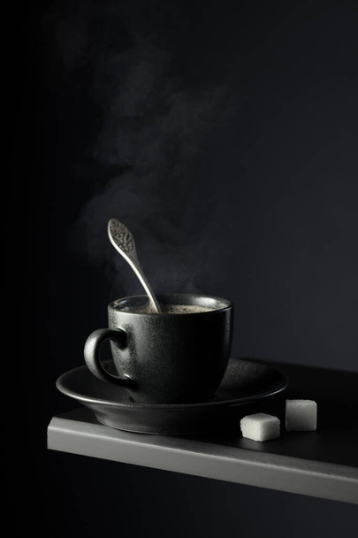 Μαύρο φλιτζάνι καφέ και ζάχαρη σε μαύρο φόντο. Αντιγραφή χώρου. - Φωτογραφία, εικόνα