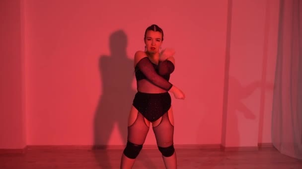 Συν μοντέλο θηλυκό σε μαύρο διαφανές crop top χορεύει στο πάτωμα στο φωτισμένο δωμάτιο στούντιο. Υψηλής ποιότητας υλικό FullHD - Πλάνα, βίντεο