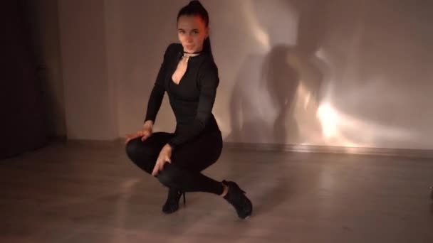 Сексуальная девушка в черной одежде танцует на оранжевом неоновом фоне, танцует в студии, замедленная съемка. Высококачественные FullHD кадры - Кадры, видео
