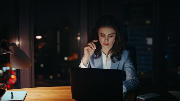 Wyczerpany pracownik biurowy, przepracowany w biurze późnym wieczorem. Zmęczona, przytłoczona bizneswoman pracująca na laptopie, czująca się niemotywowana. Profesjonalne dziewczyna menedżer patrząc monitor komputera w nocy - Zdjęcie, obraz