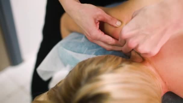 masajista está dando un masaje a la mujer en salón de belleza - Imágenes, Vídeo