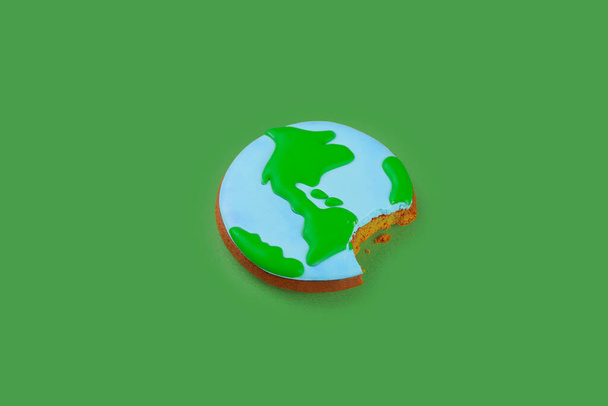 Concepto del Día de la Tierra. Galleta en forma de Tierra en mano. - Foto, Imagen