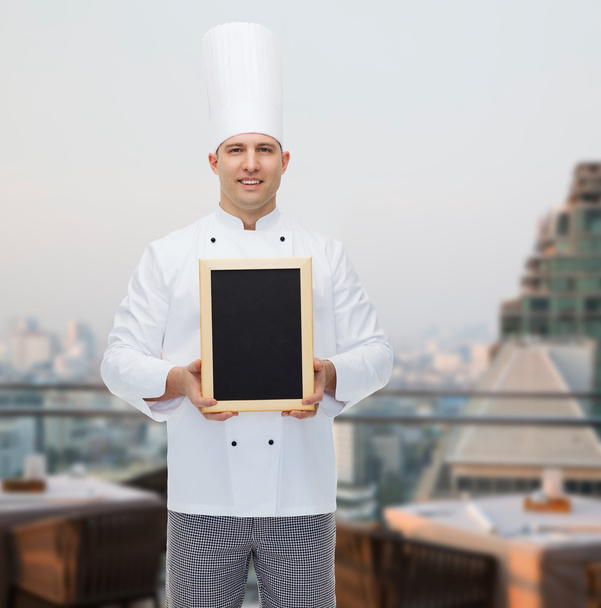 happy male chef cook holding blank menu board - Zdjęcie, obraz
