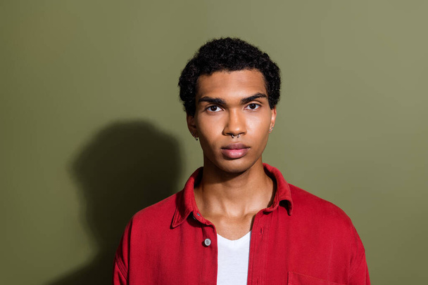 Photo of cool serious guy wear red shirt looking you empty space isolated khaki color background. - Foto, afbeelding