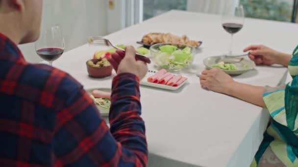 Καλλιεργημένη φωτογραφία αγνώριστου συζύγου που κρατά τις συζύγους χέρι κατά τη διάρκεια εορταστικού δείπνου στο σπίτι - Πλάνα, βίντεο