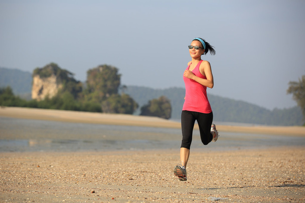 Healthy woman running at beach - 写真・画像