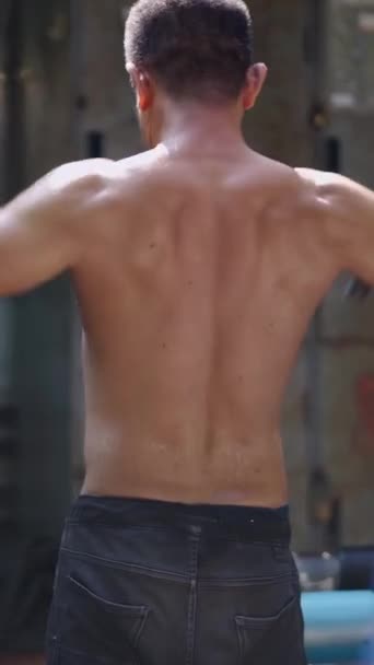 Un uomo irriconoscibile esercita le spalle con i pesi - FHD Vertical Local street gym - Filmati, video