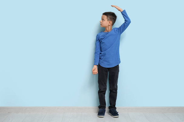 Söpö pieni poika mittaus korkeus lähellä sininen seinä - Valokuva, kuva