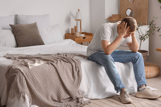 Fiatal férfi szenved fejfájás a hálószobában - Fotó, kép