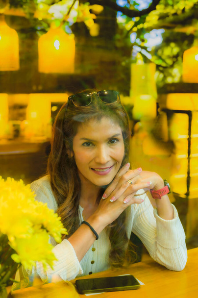 Mulher asiática olhando através de vidro com atmosfera confortável em um café na província de Chiang Mai, Tailândia. - Foto, Imagem