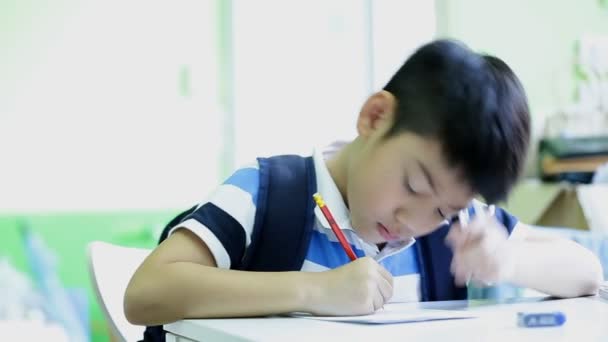 Asijské roztomilé dítě s tužkou, udělat domácí úkoly doma - Záběry, video