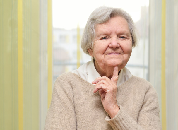 Senior happy woman in her home with window - Fotó, kép