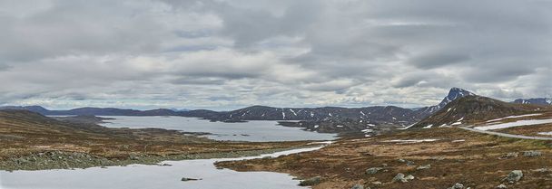 lago na paisagem montanhosa de Jotunheimen, na Noruega, com picos cobertos de neve no fundo, um destino de viagem popular para caminhadas. - Foto, Imagem