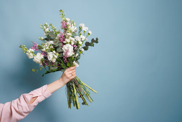 florista femenina hace un ramo en una tienda de flores, ramo de primavera - Foto, imagen