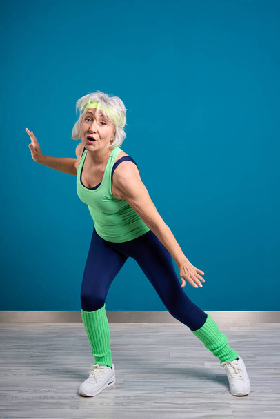 Mujer mayor mostrando fuerza y flexibilidad - Foto, Imagen