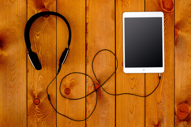 Tablet and headphone on wooden table - Foto, Imagen