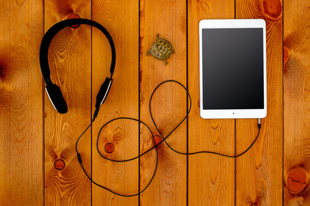 Concept with tablet and black headphones on wooden background - Zdjęcie, obraz