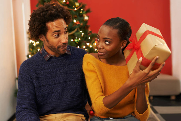 Překvapení, dárek a černý pár na Vánoce s krabicí nebo otevírací balíček na sváteční dovolenou nebo dovolenou. Nadšení, žena a muž nabízejí dárek doma s láskou, laskavostí a zvědavostí v manželství. - Fotografie, Obrázek