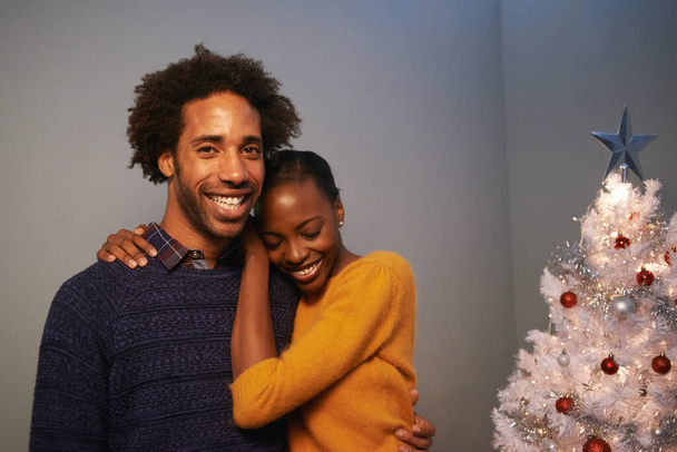 Ζευγάρι, χριστουγεννιάτικο δέντρο και γιορτή διακοπών στο σπίτι για διακοπές ευτυχία ή αγάπη, δίνοντας ή δένοντας. Άνδρας, γυναίκα και χαμόγελο με διακόσμηση φωτισμού για τη χειμερινή περίοδο, μαζί ή lounge. - Φωτογραφία, εικόνα