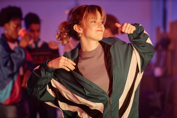 Талия портрет молодой девушки в ретро-костюме, танцующей на дискотеке 80-х в розовых огнях - Фото, изображение