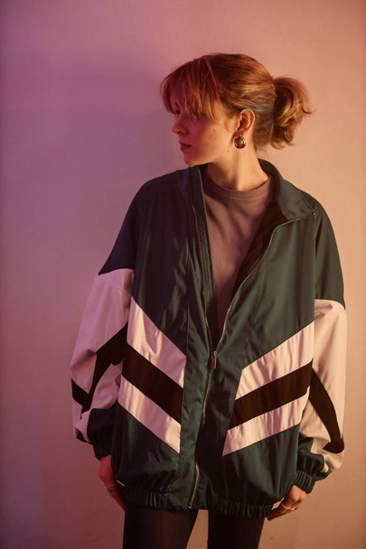 Verticaal portret van jong meisje dragen oversize retro jas in jaren 80 esthetische stijl, zijaanzicht - Foto, afbeelding
