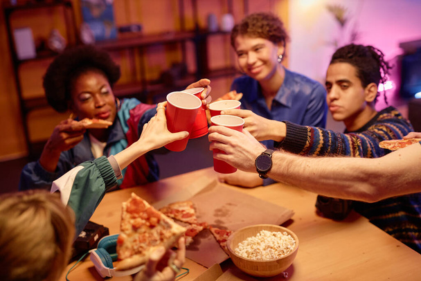 Close up of young people toasting with red cups over table at retro house party, copy space - Photo, Image