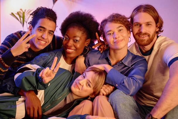 Bunte Gruppe junger Leute posiert gemeinsam auf Retro-House-Party - Foto, Bild