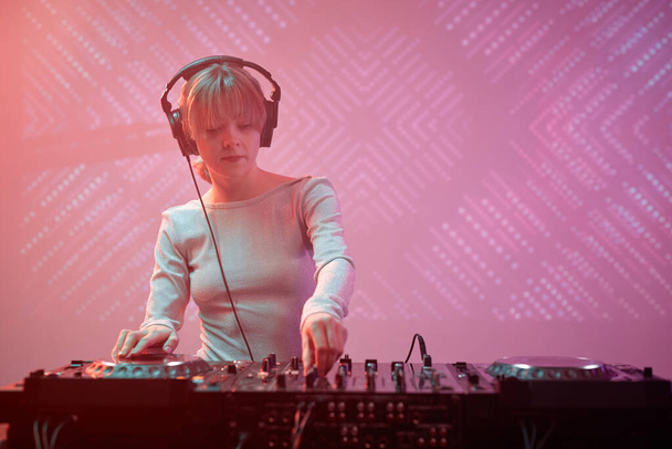 Muotokuva nuori nainen DJ yllään kuulokkeet yökerhossa, kopioi tilaa - Valokuva, kuva
