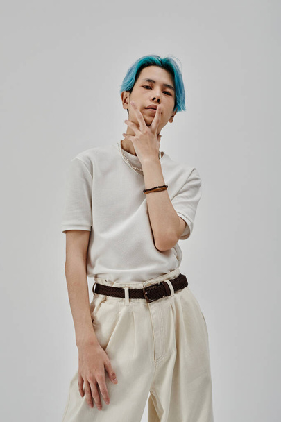 Imagem vertical de adolescente elegante com cabelo azul posando na câmera em pé no fundo branco - Foto, Imagem