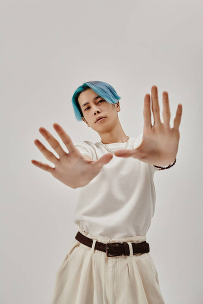 Vertical image of young dancer with blue hair posing at camera standing on white background - Photo, Image