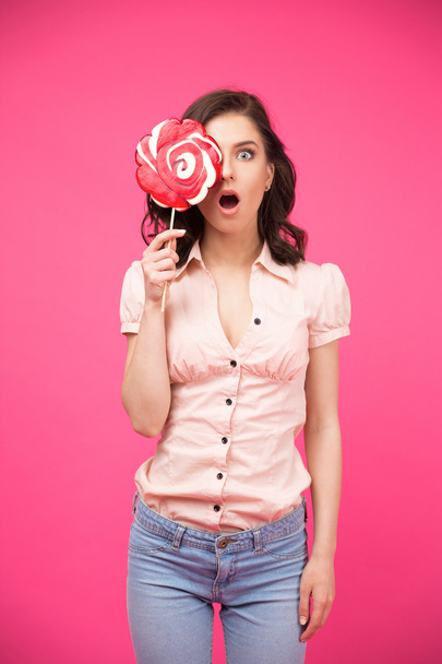 Woman covering her eye with lollipop - Фото, изображение