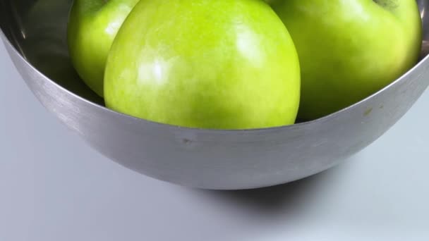 Manzanas verdes en cuenco de metal sobre fondo gris de cerca - Metraje, vídeo