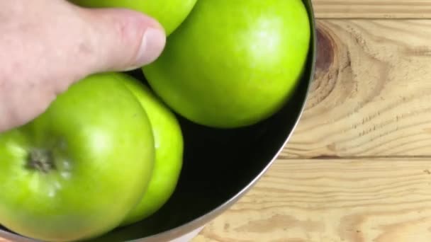 Grüne Äpfel in Metallschale und ein Apfel in der Hand - Filmmaterial, Video
