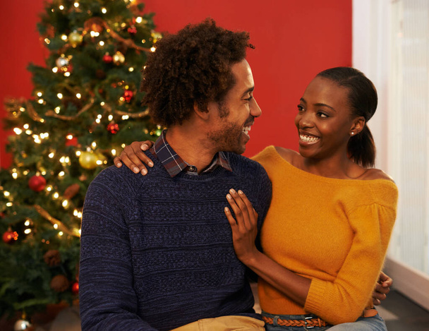Paar, Weihnachtsbaum und festliche Feiertage oder zu Hause mit Glück für Urlaubsfeiern, Geschenke oder Bindung. Mann, Frau und Lächeln mit Beleuchtungsdekoration für die Wintersaison, zusammen oder in der Lounge. - Foto, Bild
