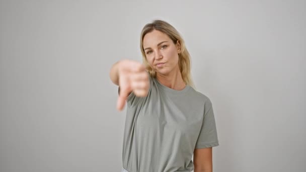 不承認または否定的なフィードバックを表す白い背景の前に親指を与える白人女性 - 映像、動画