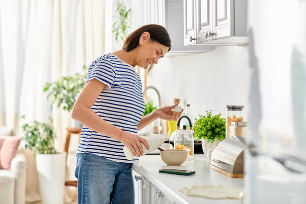 Eine Frau in gemütlicher Hauskleidung steht in einer Küche und bereitet Essen zu. - Foto, Bild