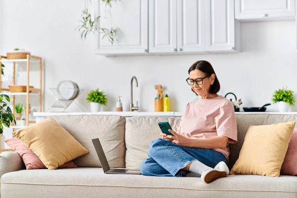 Woman in cozy homewear using laptop on couch. - Photo, Image