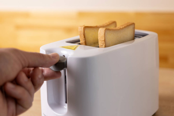 Щоб зробити тост, хліб завантажується в електричний  - Фото, зображення