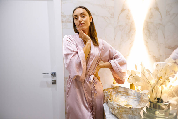 Urban Spa Retreat: Aantrekkelijke vrouw in strakke badkamer ruimte - Foto, afbeelding