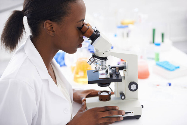 Onderzoek, microscoop of vrouwelijke wetenschapper in functie voor medische, experiment of inspectie. Wetenschap, gezondheidszorg of Afrikaanse gezondheidsdeskundige met virusstudie, testen of DNA-analyse voor laboratoriumonderzoek. - Foto, afbeelding