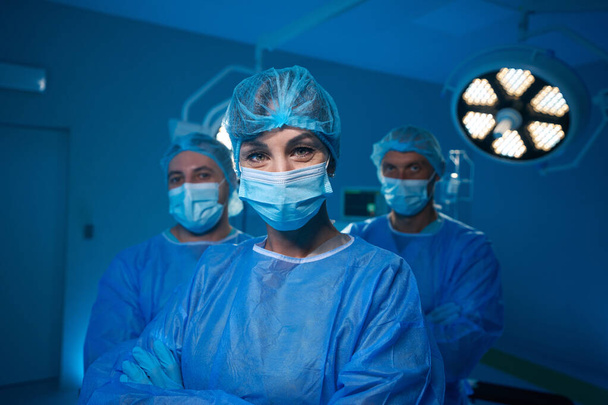Zespół medyczny po operacji na sali operacyjnej zadowolony z pozytywnego wyniku swojej pracy - Zdjęcie, obraz