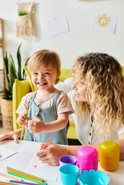 Kudrnatá matka a její batolata dcera se angažují v Montessori učení u domácího stolu, se zaměřením na vzdělávání. - Fotografie, Obrázek
