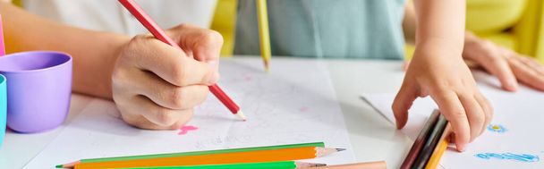 обрезанная женщина сосредоточилась на рисовании на бумаге с красочными карандашами, занимаясь художественной деятельностью с творчеством. - Фото, изображение