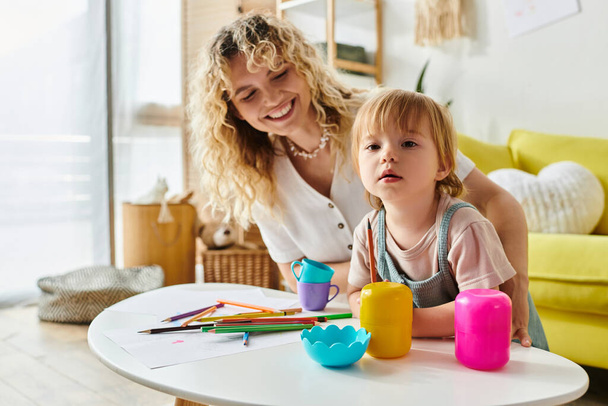 Una madre dai capelli ricci e sua figlia bambina si impegnano gioiosamente in un gioco basato su Montessori a casa con giocattoli colorati. - Foto, immagini