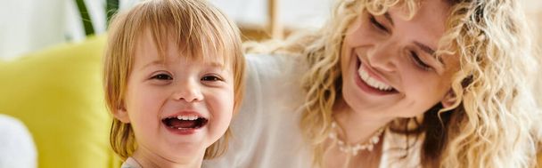 A curly mother and her toddler daughter share a moment of joy and laughter while engaging in Montessori education at home. - Photo, Image